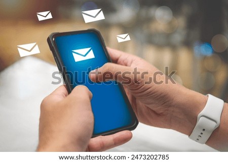 A man uses a smartphone to send and receive emails. For business and commercial communication.
