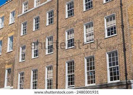 Facade of a brick building with a symmetrical arrangement of sash windows in London, England