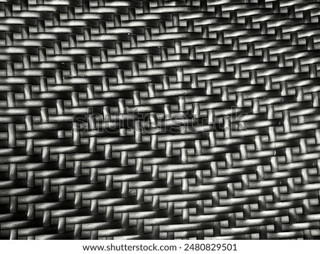  Close-up of a black and white plastic weave pattern. Tightly woven texture for furniture or basketry
