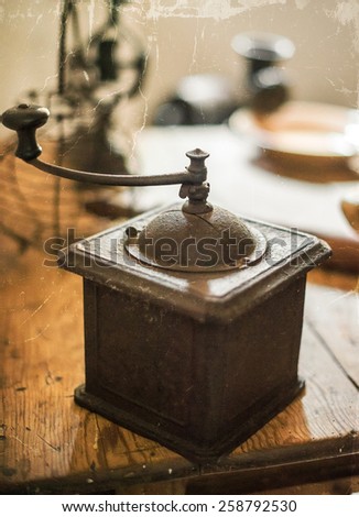 Vintage manual coffee grinder on the table. Old photo effect.