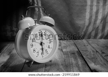Cloth background with retro alarm clock on table