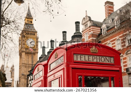 Classic red British telephone boxes with Big Bang in the background.