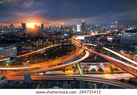 Traffic on tollway capital city, Night rooftop view dark skyline bangkok twilight, office buildings, living, condominium in bangkok city  skyline top view Downtown and business office bank financial 