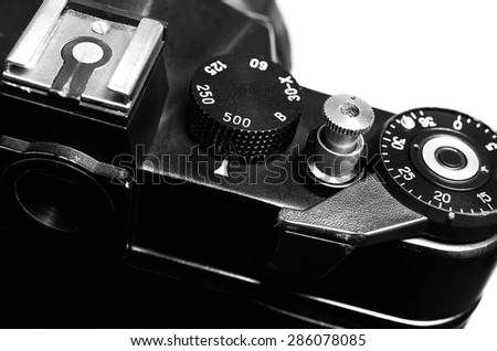 Old film DSLR camera. The wheel of choice shutter, frame counter and shutter button. Close up view. Macro. Selective focus. Vintage photo. Black and white.