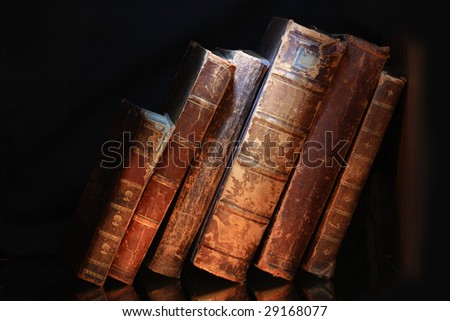 Old books in a row isolated on dark background