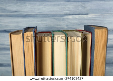 Stack of books on wooden table on blue wooden wall background