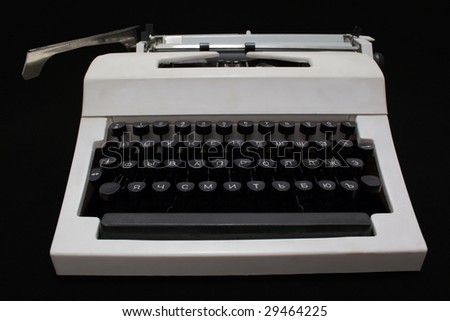 white mechanical typewriter without a paper on a black background