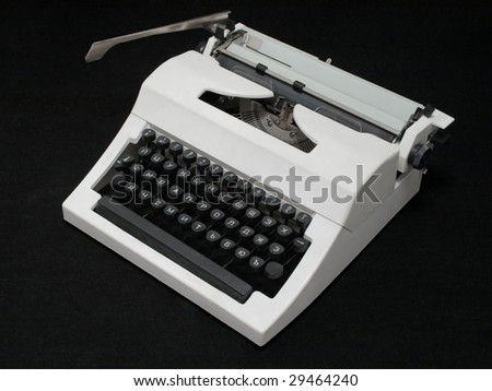 white mechanical typewriter with a paper sheet on a black background