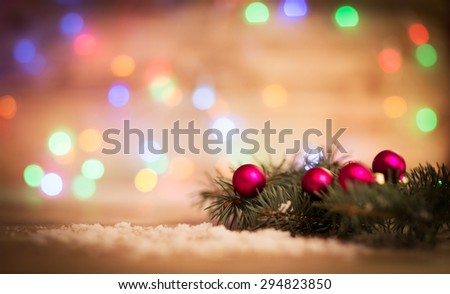 Closeup of a red Christmas balls and fir-tree branches on wooden background.