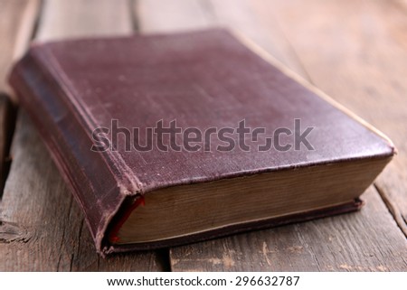 Old book on wooden table close up