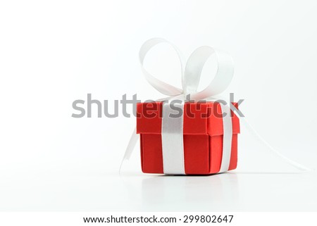 Close up of red gift box with ribbon over white background