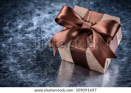 Boxed gift with present tape on metallic background holiday concept.