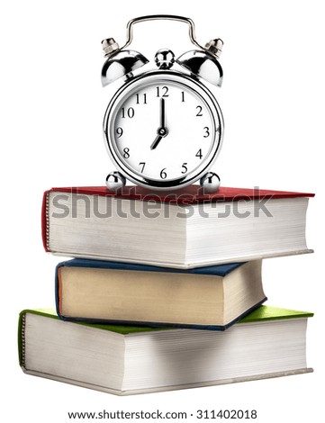 Vintage clock alarm on stack of books isolated