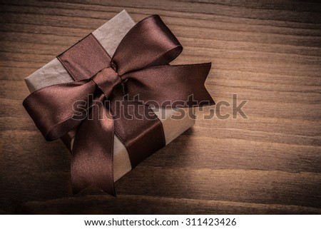 Wrapped gift on vintage wood board horizontal view holidays concept.