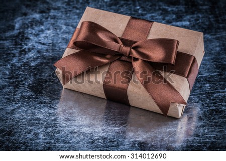 Vintage giftbox with tied bow on metallic background holiday concept.
