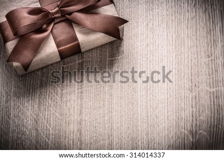 Gift box with brown bow on wooden board celebration concept.