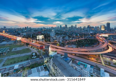Twilight of city freeway intersection and business area on background, Bangkok Thailand