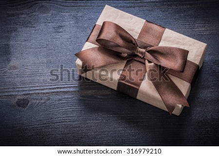 Gift box-container with bow on vintage wooden board.