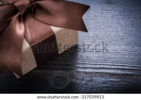 Boxed present with tied bow on vintage wooden surface.