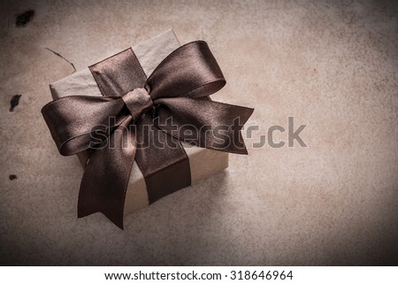 Present box with tied bow paper on vintage background.