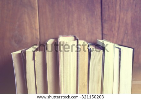 Books on a wooden background, vintage color effect