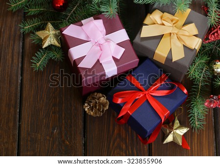 gift boxes with festive ribbons and Christmas decorations on a wooden background