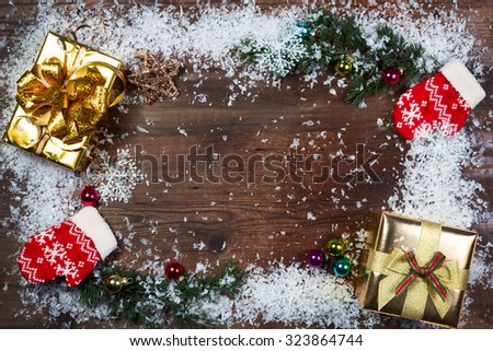 Fir branches with gifts and decorations covered with snow