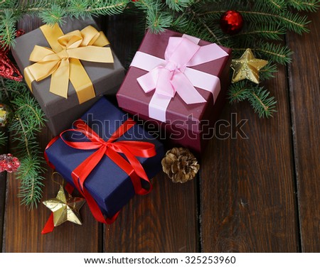 gift boxes with festive ribbons and Christmas decorations on a wooden background