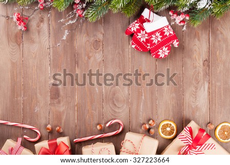 Christmas wooden background with snow fir tree and gift boxes. View with copy space