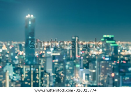 Blur city background rooftop view of Bangkok cityscape business building landscape night lights bokeh in vintage blue tone