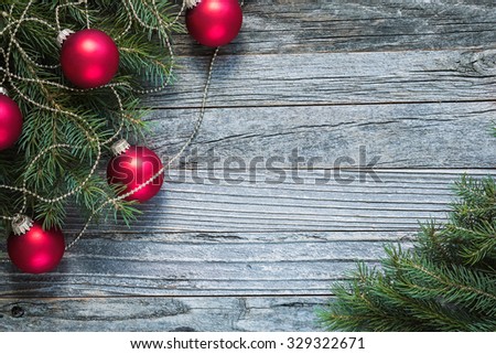 Christmas fir tree branches with decorations on an old wooden background, copy space for text, top view.