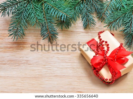 Christmas wooden background. Branch of fir tree and box of gift.
