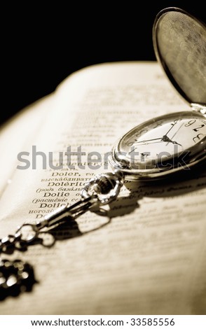 shadow and pocket watch on a old book