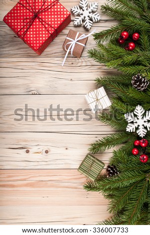 Fir tree with christmas decorations and gift boxes on wooden background