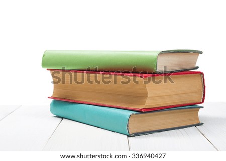 Stack of books on wooden table isolated on white background. Back to school. Copy space for text