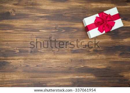 White gift box for holiday event red silk wrap on Wood background isolated