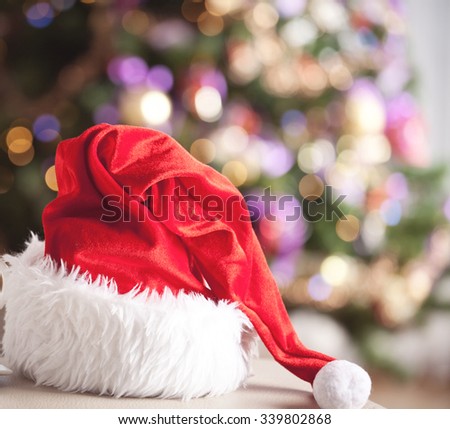 Santa Claus red hat in front of a christmas tree. Christmas background