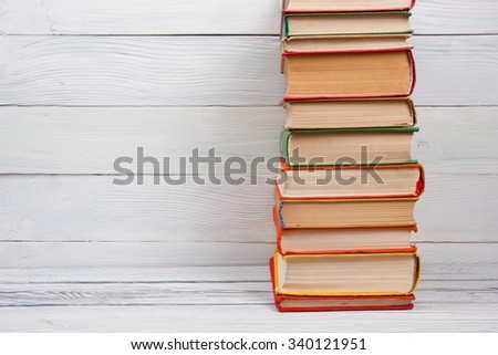 Stack of colorful books on wooden table. Back to school. Copy space for text
