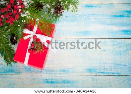 Christmas red gift box with a white ribbon and decorations on a blue background. Top view, copy space.