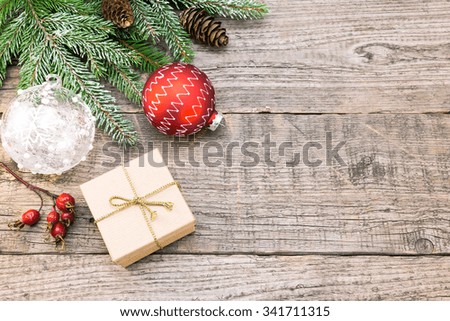 christmas holiday background with gift box, glass bauble and snowy fir branches
