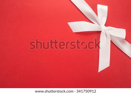 Decorative white ribbon and bow on cardboard 