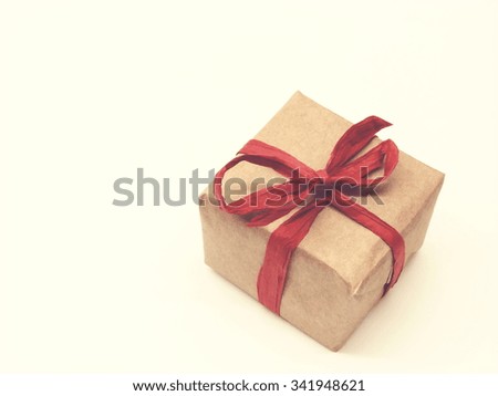 gift package wrapped in gray paper with organic red ribbon; background; vintage filter effect