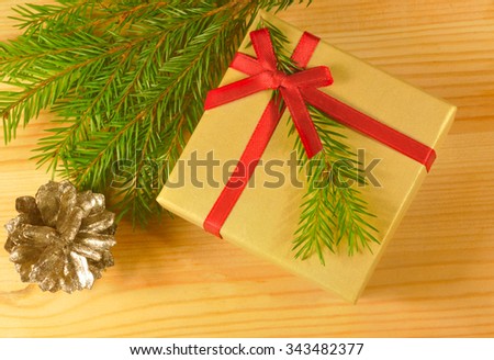 Gift box with red ribbon and fir branch
