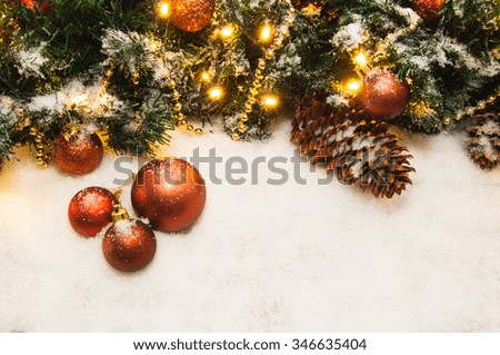 Christmas tree branches with red balls, golden garland, snowflakes and fir-cone