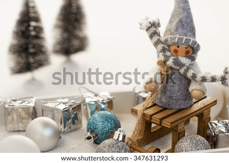 Cute gnome delivers christmas gifts on wooden sled. Fun christmas composition with a wooden toy.