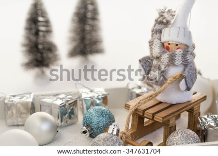 Little cute gnome on wooden sled with chrismas ornaments and gift boxes. 