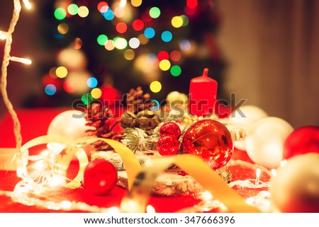 Christmas decoration. Candle, pine cones, bulbs, decorative band... Shallow depth of field.