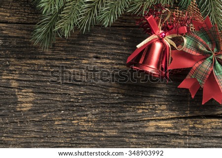 Still life of christmas ornament and tree branch on wooden board.