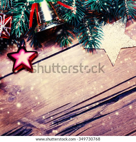 		Christmas background with winter decorations and snowfall  on a wooden background. Christmas Card with  Retro filter effect.

