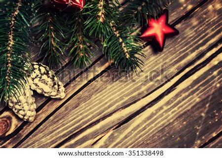 	Christmas background with christmas fir tree, gift, red star and snow on a wooden background. Christmas Card with  Retro filter effect. 